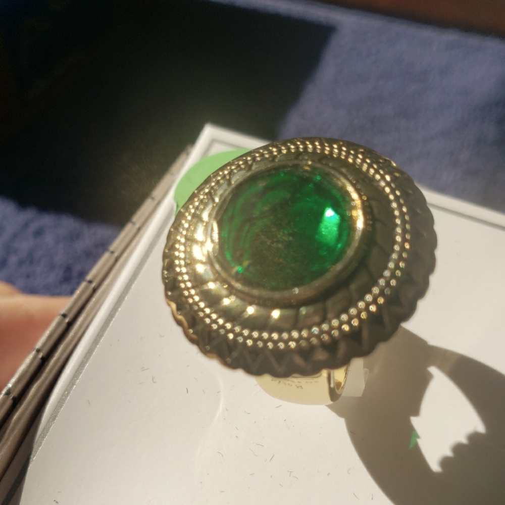 Gold tone ring with Emerald colored setting.  Size 8